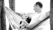 father and son sitting in a hammock