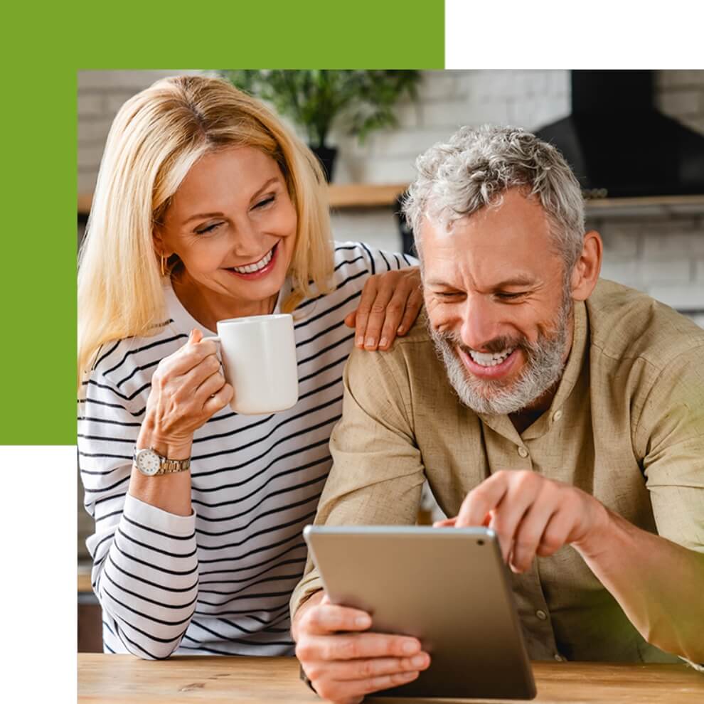 Senior Couple drinking coffee and looking at a tablet